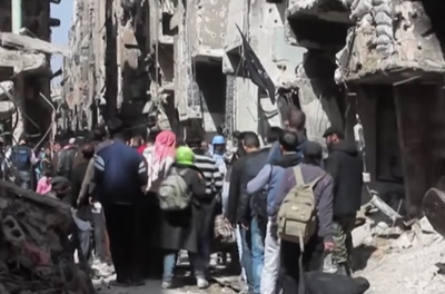 Palestyczycy uciekaj z obozu dla uchodców, Jarmouk w pobliu Damaszku po zaciekych walkach we wrzeniu 2015 r.  (Zrzut z ekranu z wideo RT)
