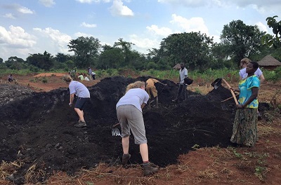 Farmerzy i wolontariusze pracuj z organicznym nawozem w orodku  Uganda Community Farm. (Zdjcie: UCF)