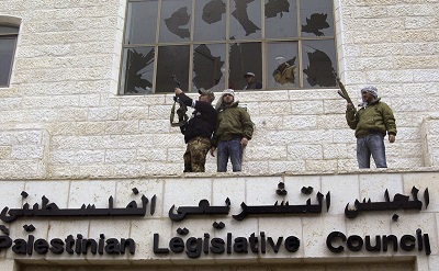 Na zdjęciu: Uzbrojeni członkowie palestyńskiego Fatahu okupują budynek Palestyńskiej Rady Ustawodawczej w Ramallah i strzelają w powietrze 28 stycznia 2006 r. w proteście przeciwko zwycięstwu Hamasu nad ich partią w wyborach, które odbyły się trzy dni wcześniej. (Zdjęcie:  Zharan Hammad/Getty Images)