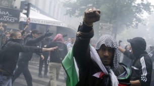 Uczestnik protestu, w kefiji i owinity flag palestysk, 13 lipca 2014 r. w Paryu, podczas demonstracji przeciwko Izraelowi i w poparciu dla mieszkaców Strefy Gazy (zdjcie: AFP/KENZO TRIBOUILLARD)