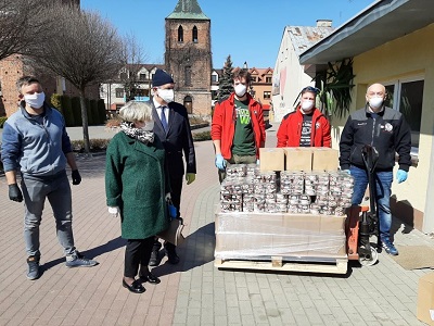 Płońsk. Przygotowanie do rozwiezienia żywności pod drzwi podopiecznych MOPS objętych Programem Operacyjnym Pomoc Żywnościowa przez wolontariuszy Stowarzyszenia „Idziemy na spacer”.