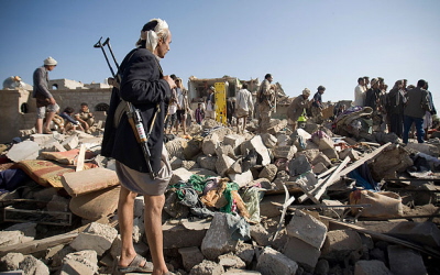Jemeski partyzant nadzoruje poszukiwanie ocalonych w budynku zburzonym przez lotnictwo saudyjskie.