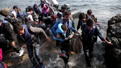 Uchodcy syryjscy lduj na wybrzeu greckiej wyspy Lesbos w nadmuchiwanym pontonie, którym przepynli Morze Egejskie z Turcji, 3 wrzenia 2015. (AFP/Angelos Tzortzinis)