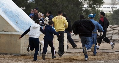 Izraelczycy biegną do schronu podczas palestyńskiego ataku rakietowego na Beer Szewę 23 marca 2011 r. Zdjęcie: Menahem Kahana/AFP via Getty Images.