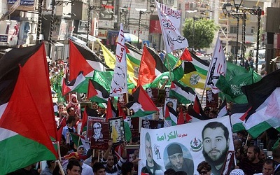 Przez kilka minionych tygodni tysiące Palestyńczyków w Jerozolimie i na Zachodnim Brzegu demonstrowały, by poprzeć Hamas, szczególnie po tym, jak wystrzelił tysiące rakiet i pocisków na Izrael. Na zdjęciu: Tłum Arabów wymachuje flagami Hamasu w Ramallah. (Zdjęcie: Issam Rimawi/Flash 90)