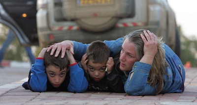 Izraelska matka chroni swoje dzieci podczas alarmu rakietowego w kibucu Kfar Aza w południowym Izraelu, 7 stycznia 2009 (Zdjęcie: JACK GUEZ/AFP via Getty Images)