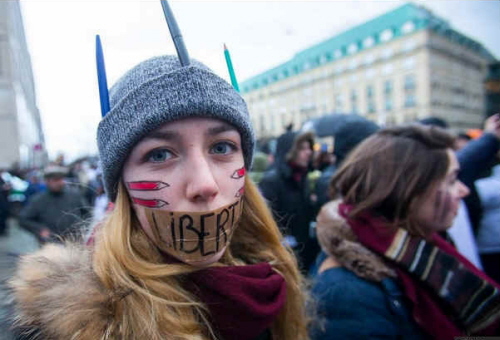 Kobieta z ustami zaklejonymi plastrem z napisem 'Liberte' na ustach podczas marszu solidarności w Paryżu. (zdjęcie: REUTERS)