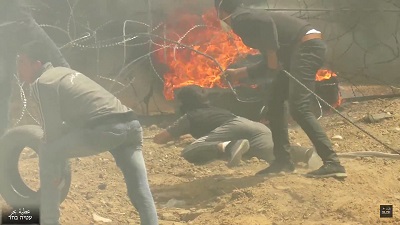 Na zdjciu: Palestyczycy w Gazie próbuj przedrze sie przez pot graniczny z Izraelem korzystajc z zasony dymnej. 30 marca 2018. (Zrzut z ekranu z wideo Ateya Bahar).
