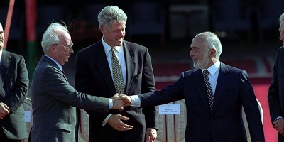 Izraelski premier, Icchak Rabin i jordański król, Hussein w obecności prezydenta Clintona podają sobie ręce (26października 1994 r.) Zdjęcie: Wikimedia Commons.