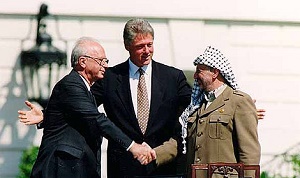 PRZEWODNICZĄCY OWP Jaser Arafat podaje rękę premierowi Icchakowi Rabinowi, do czego zachęca go prezydent USA Bill Clinton, po podpisaniu Deklaracji Zasad w Białym Domu, 13 września 1993 r. (Zdjęcie: Wikipedia)