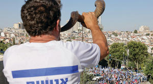 MʯCZYZNA w koszulce z napisem „Wszyscy jestemy brami” dmie w szofar w pobliu Sdu Najwyszego w Jerozolimie, wzywajc do jednoci z antyreformatorskimi demonstrantami.(zdjcie: MARC ISRAEL SELLEM/THE JERUSALEM POST)
