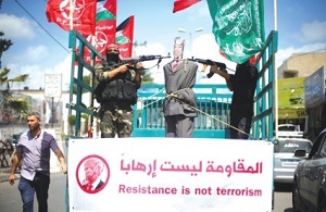 CZŁONKOWIE Ludowego Frontu Wyzwolenia Palestyny (LFWP) celują bronią w wizerunek przedstawiający prezydenta USA Donalda Trumpa podczas protestu w Gazie. (zdjęcie: REUTERS)