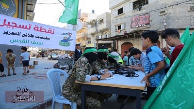 Hamas wezwa Palestyczyków w Strefie Gazy do rejestrowania swoich synów na letnie obozy wojskowe. „Celem obozów jest rozpalenie pomieni dihadu w pokoleniu wyzwolenia, wpojenie islamskich wartoci i przygotowanie nastpnej zwyciskiej armii do wyzwolenia Palestyny” – oznajmi Hamas. Na zdjciu:Stoisko rejestracyjne dla “Pionierów wyzwolenia – obozów Miecz Jerozolimy” (ródo: T.me/Tlae3Camps, 17 czerwca 2021)