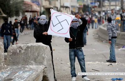 Palestyscy demonstranci trzymaj swastyk w antyizraelskim protecie na Zachodnim Brzegu.(Zdjcie: REUTERS)