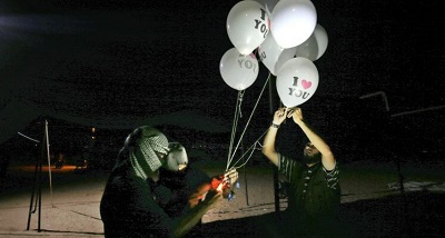Zamaskowani Palestyczycy, nazywajcy siebie „jednostkami nocnego zamieszania”, trzymaj zapalajce urzdzenia przyczepione do balonów, który wypuszcz w stron Izraela. Zdjcie z granicy midzy Gaz a Izraelem na wschód od Rafah z 26 wrzenia 2018. (Zdjcie:  KHATIB/AFP via Getty Images)
