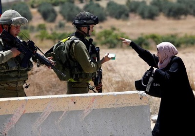 Palestyska kobieta w sprzeczce z onierzami izraelskiej armii na punkcie kontrolnym w obozie uchodców Al-Fawwar na Zachodnim Brzegu na poudnie od Hebronu (zdjcie: REUTERS/MUSSA QAWASMA)