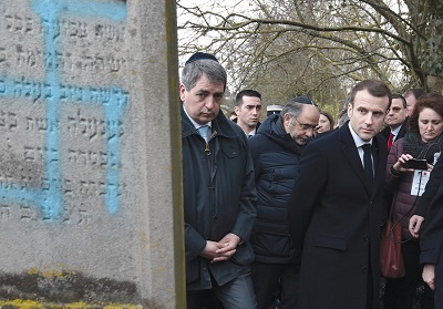 Emmanuel Macron patrzy na grób z wymalowan swastyk podczas wizyty na ydowskim cmentarzu w Quatzenheim 19 lutego. (zdjcie: FREDERICK FLORIN/POOL/VIA REUTERS)