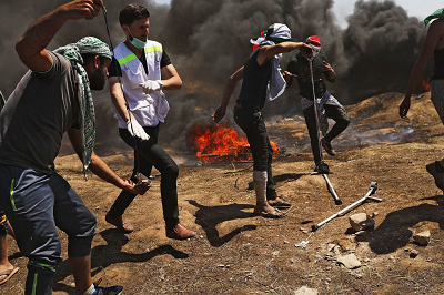 Na zdjciu: Grupa Palestyczyków podczas rozruchów przy granicy z Izraelem 14 maja 2018 r. Dwóch modych mczyzn przygotowuje atak procami na izraelskich onierzy. (Zdjcie: Spencer Platt/Getty Images)