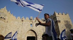 Mężczyzna macha izraelską flagą przed Bramą Damasceńską w Jerozolimie( zdjęcie: Alex Kołomojski )