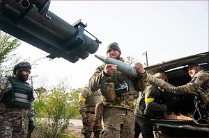Grupa ukraińskich żołnierzy ładuje rakietę pod osłoną drzew w obwodzie chersońskim w październiku.