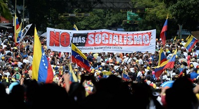 Demonstranci z transparentem “nie chcemy więcej socjalizmu” podczas wiecu opozycji z udziałem opozycyjnego przywódcy Juana Guaido, w Caracas 2 lutego 2019.<div> </div>