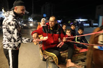 Palestyńczyk rozdający słodycze na ulicy w Gazie z okazji zabicia pięciu Izraelczyków przez palestyńskiego terrorystę. 29 marca 2022r. Zdjęcie Ashraf Amra. Twitter.