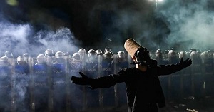 Semazen, czyli derwisz, w masce gazowej na antyreimowej demonstracji w Stambule