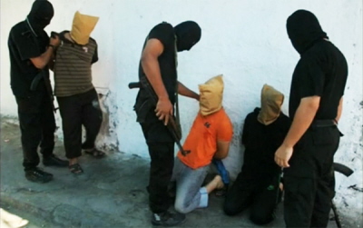 Zamaskowani czonkowie Hamasu (ubrani na czarno) przygotowuj egzekucj miejscowych Palestyczyków, którzy, jak twierdz, szpiegowali na rzecz Izraela, 22 sierpnia 2014, w Gazie. (Zdjcie: Reuters, zrzut z ekranu)