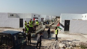 Arabscy przesiedlecy machajcy palestysk flag, gdy wprowadzaj si do swoich nowych domów zbudowanych z palestyskich darowizn w kurdyjskim miecie Afrin. Data: 28 sierpnia 2022 r. (ródo: Wafaa Al-Mohsenin) Ajnadina)