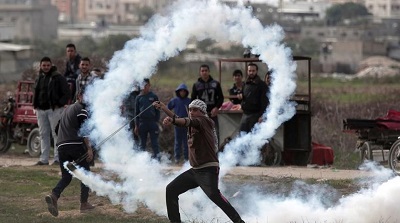 Palestyński uchodźca pokojowo protestuje przy płocie granicznym.
