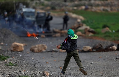 Palestyski chopiec rzuca kamieniami w izraelskich onierzy podczas star na Zachodnim Brzegu(zdjcie: REUTERS)