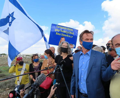 Sven Kühn von Burgsdorff (w niebieskiej koszuli) oraz tajemniczy rzekomi europejscy dyplomaci. Z tyu protestujcy z plakatem goszcym: „Unio Europejska, twoje pienidze zabiy Rin Shnerb R.I.P.”