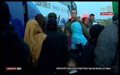 Syryjskie matki i dzieci wsiadaj do autobusu, jadcego do izraelskiego szpitala, z reportau telewizyjnego nadanego 19 listopada 2017 (zrzut z ekranu, Hadashot News)